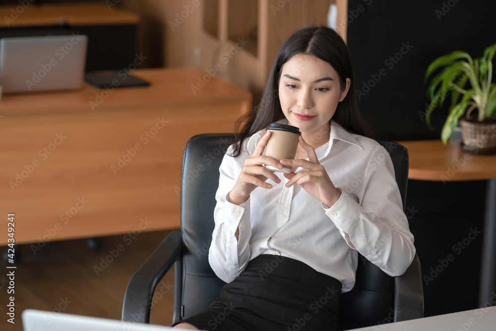 Asian businesswoman happy relaxing and drinking coffee at the office. Asian businesswoman happy relaxing and drinking coffee at the office.