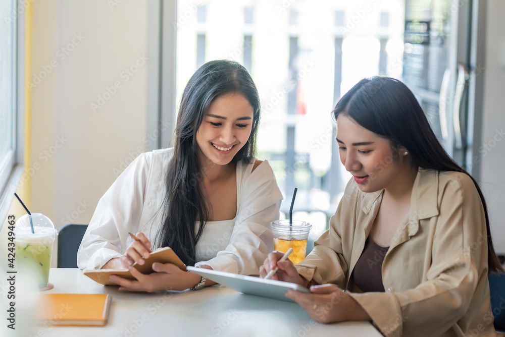 Two beautiful young Asian woman working together at a coffee shop. Two beautiful young Asian woman working together at a coffee shop.