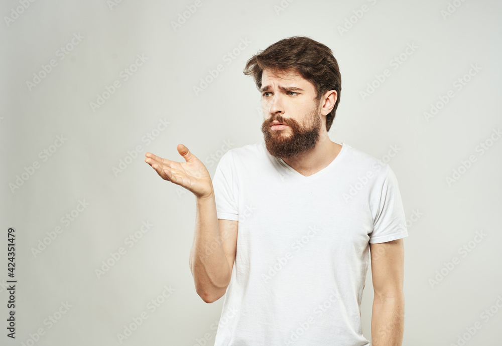 Guy on a white background gestures with his hands in a T-shirt cropped view Guy on a white background gestures with his hands in a T-shirt cropped view