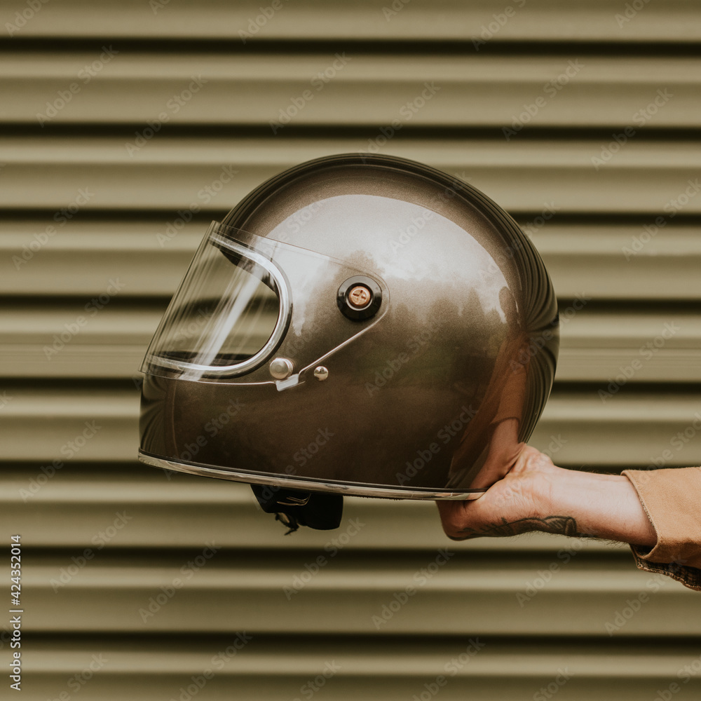 Fototapeta premium Tattoo hand holding a black helmet