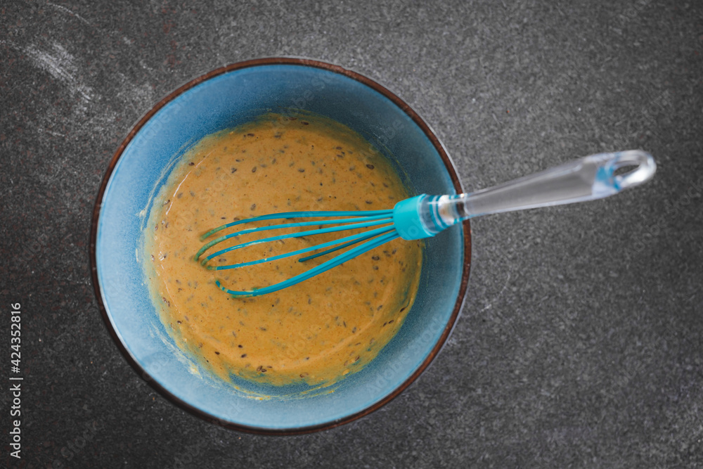 vegan batter mix for savoury muffins with olives and nutritional yeast in bowl with whisk, healthy plant-based food vegan batter mix for savoury muffins with olives and nutritional yeast in bowl with whisk, healthy plant-based food