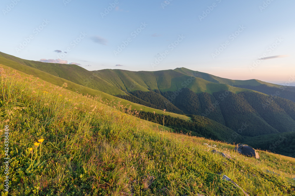 Summer evening in the Ukrainian Carpathian mountains on Borzhava with a dramatic sunset and tourists watching it