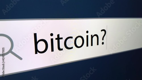 Bitcoin written in search bar with cursor, computer monitor, close-up with zoom effect