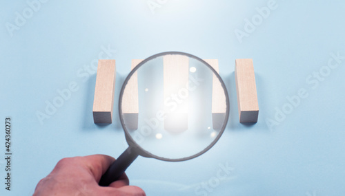 Magnifier. Lens. Wooden cubes bars. Folded in a row. On a blue background.