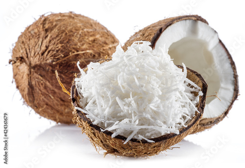Coconut fruit and shredded coconut flakes in the piece of shell isolated on white background.