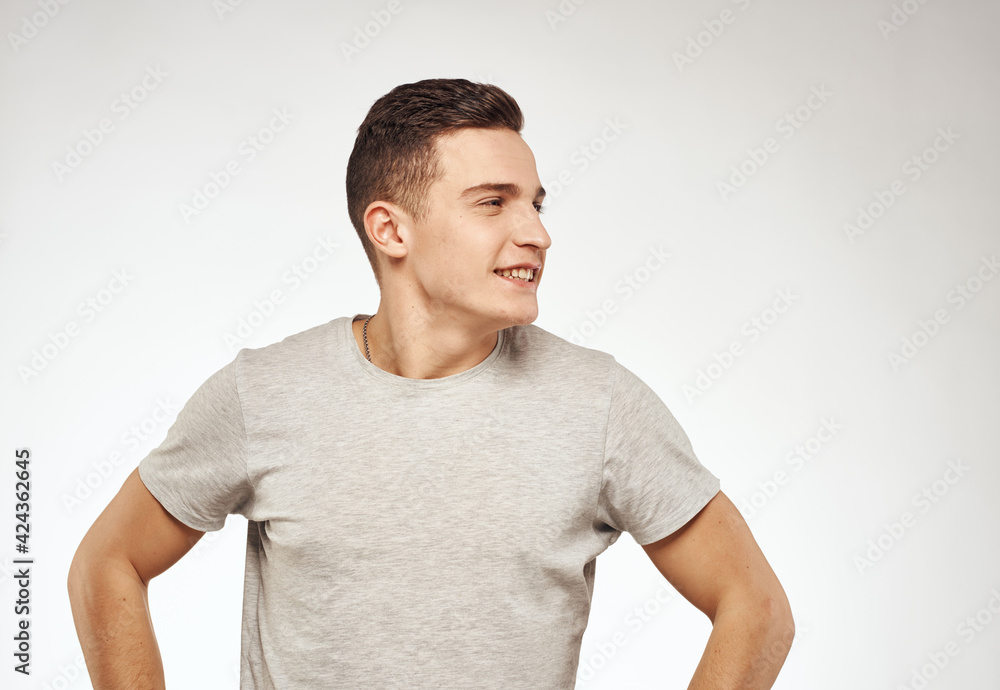 handsome man in a t-shirt gesturing with his hands emotions studio light background handsome man in a t-shirt gesturing with his hands emotions studio light background