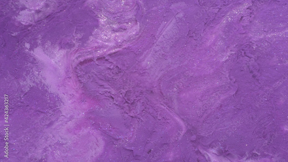 Liquid purple cosmetic shimmering product. Abstract glitter metalic background. A real beautiful substance flows. Macro. Motion mixed colorful ink
