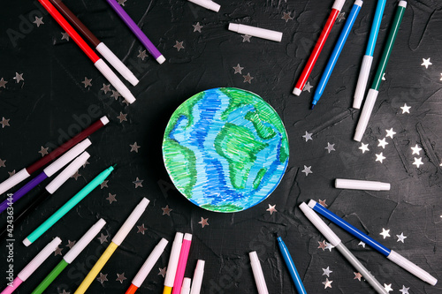 Drawn planet Earth with multicolored felt-tip pens on on a black background wih stars. Education, science, ecology, environmental protection.