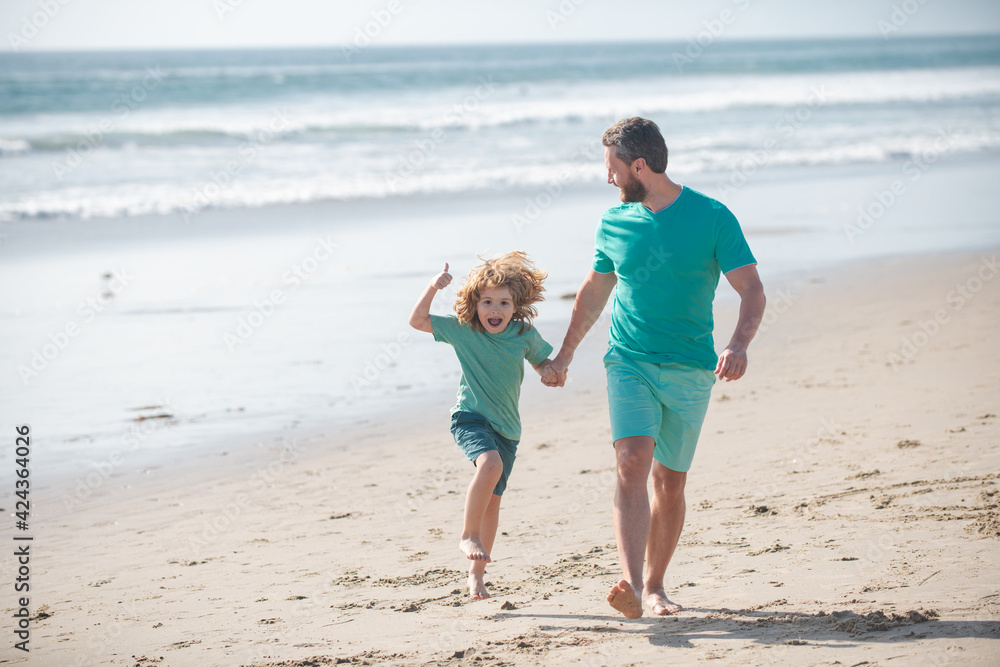 Dad and child having fun outdoors. Father and son running on summer beach. Dad and child having fun outdoors. Father and son running on summer beach.
