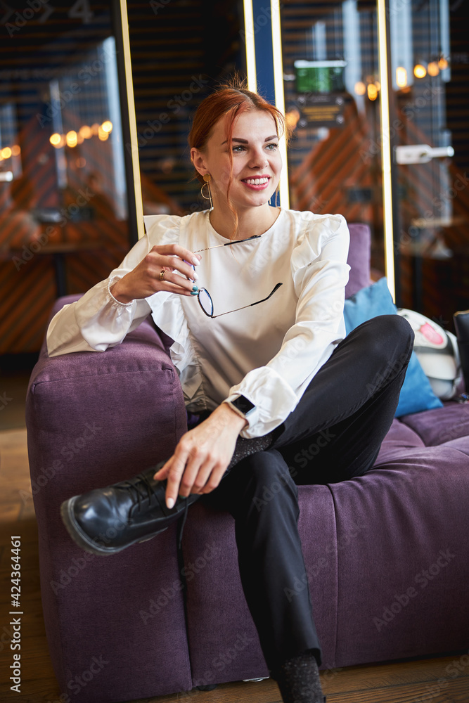 Obraz premium Charming young woman sitting on couch in office