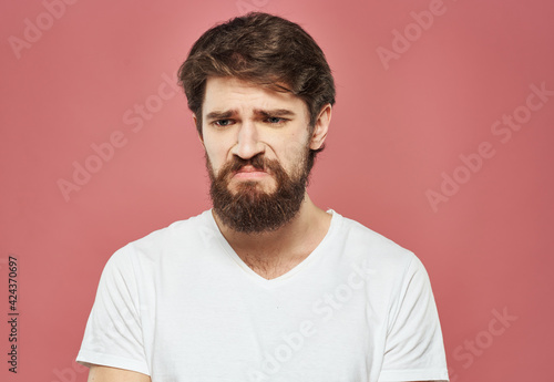 Man on pink background emotions model cropped view puzzled look sad face