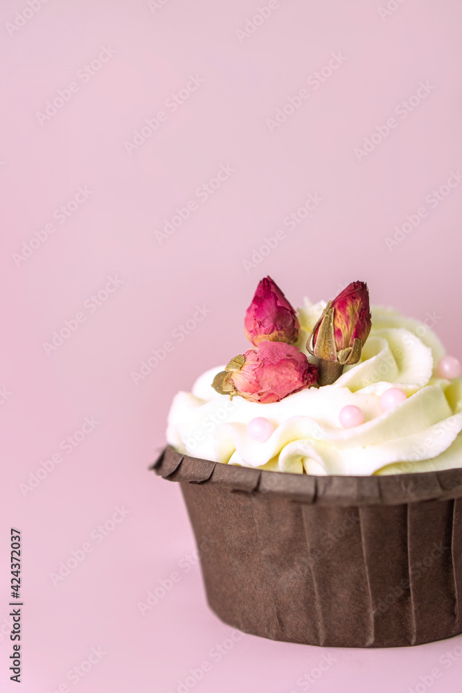 cupcakes with vanilla cream decorated with roses on pink background with  copy space for text .Vertical . Valentines and wedding  concept ,card .