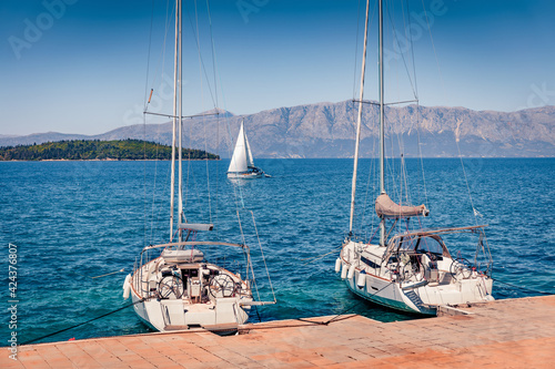 Wonderful morning view of small port of Perigiali village with two luxury yachts. Sunny summer seascape of Ionian Sea. Captivating outdoor scene of Lefkada island, Greece, Europe. photo