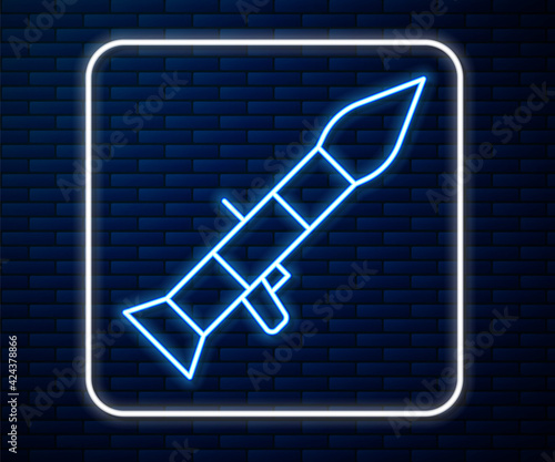 Glowing neon line Rocket launcher with missile icon isolated on brick wall background. Vector