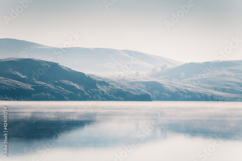Beautiful lake in misty morning. Mountains reflected in the calm water surface. Autumn landscape. South Ural, Russia. © smallredgirl