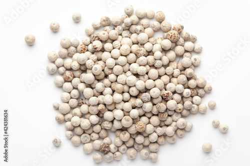 Macro close-up of Organic White peppercorns (Piper nigrum) on white background. Pile of Indian Aromatic Spice. Top view