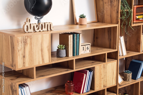 Modern shelf unit with books and decor, closeup photo