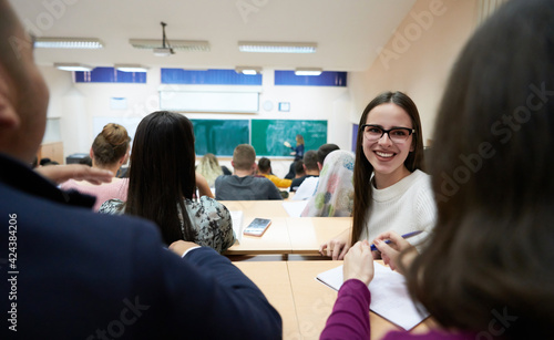 girl sitting in an amphitheater and talking to her colleagues