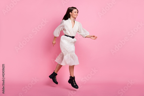 Full size profile photo of optimistic brunette lady jump go wear dress shoes isolated on pink color background