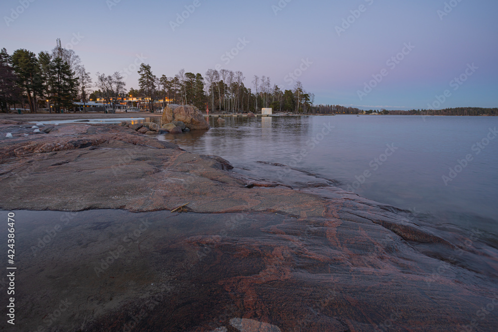 Rocky coast and sea. Finland, Scandinavian nature. Evening seascape, early spring, Long exposure.
