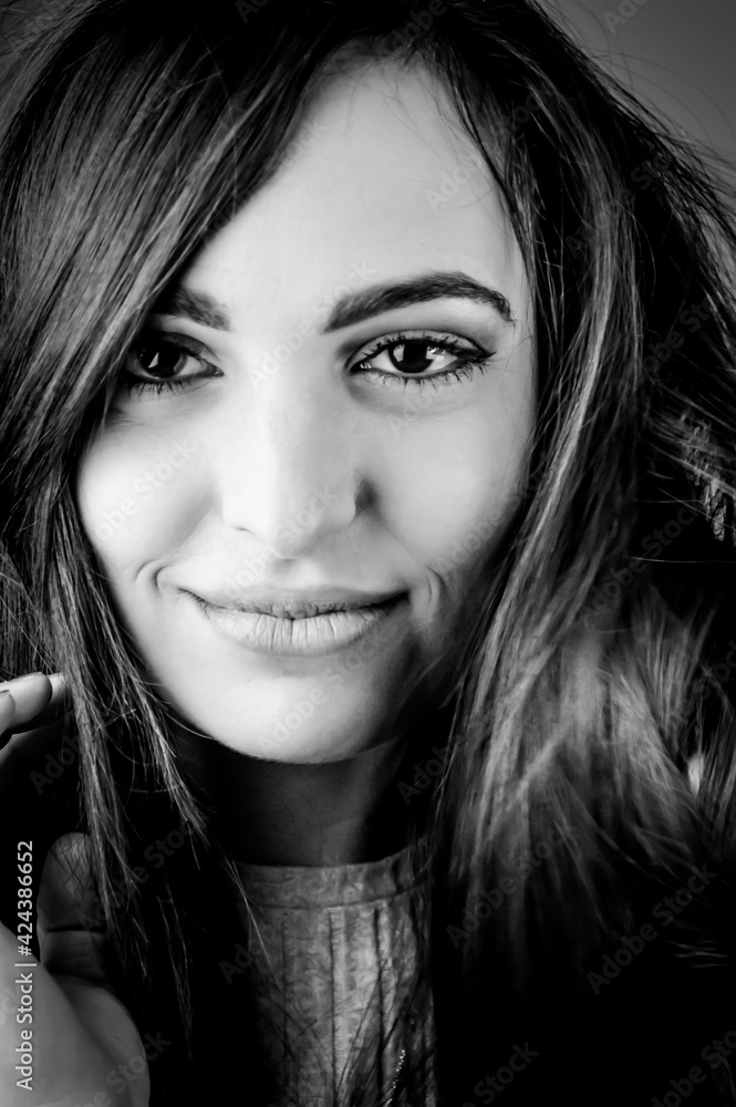 Close up black and white portrait of a beautiful young smiling woman with long dark hair Close up black and white portrait of a beautiful young smiling woman with long dark hair