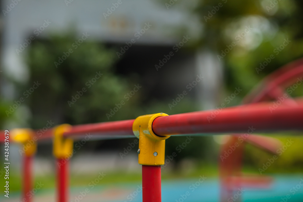 details of the playground, metal and plastic structures from a red metal straight pipe