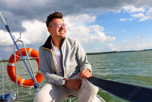 Young man takin sunbath on a sailboat during sailing. © lenaivanova2311