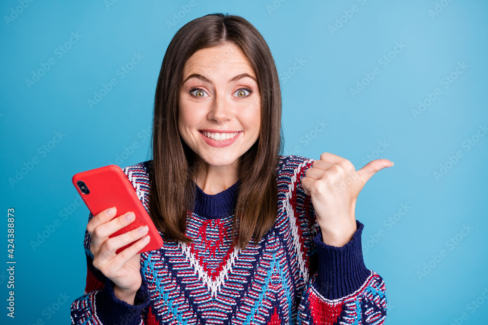 Portrait of attractive cheerful amazed girl using device demonstrating copy space offer isolated over bright blue color background Portrait of attractive cheerful amazed girl using device demonstrating copy space offer isolated over bright blue color background