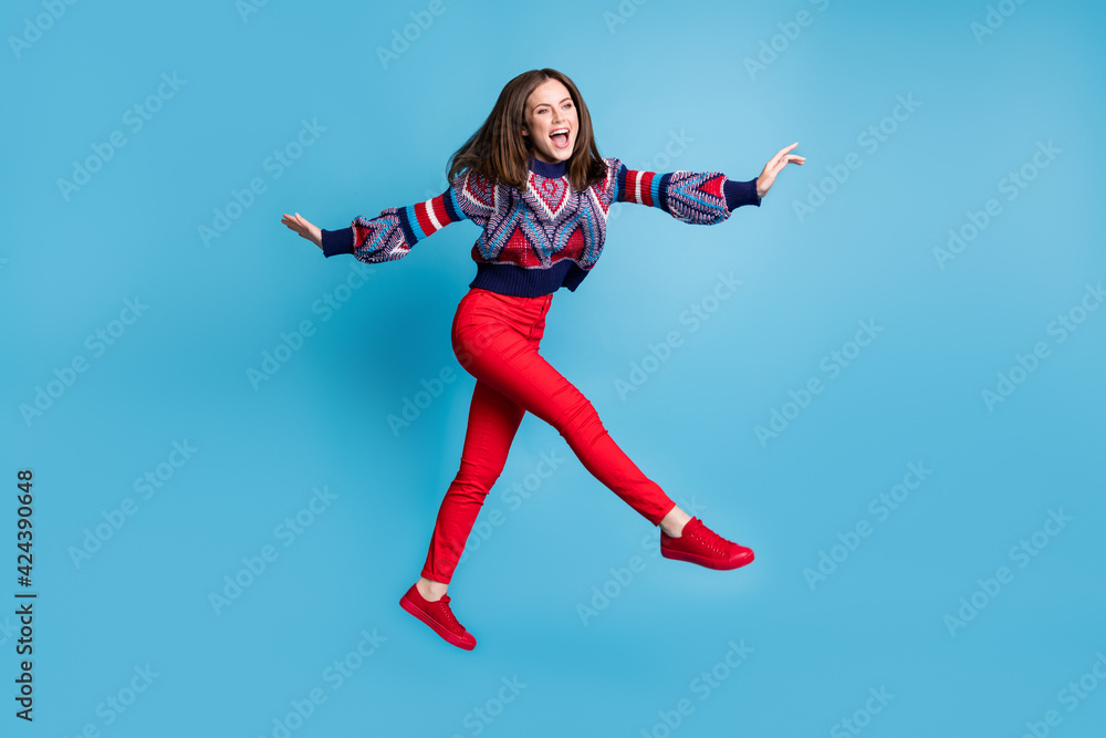 Full length body size view of attractive cheerful girl jumping walking fooling having fun isolated over bright blue color background
