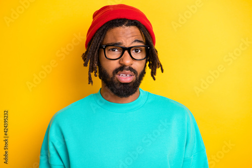 Photo of young african man unhappy sad upset uncertain unsure wear glasses isolated over yellow color background