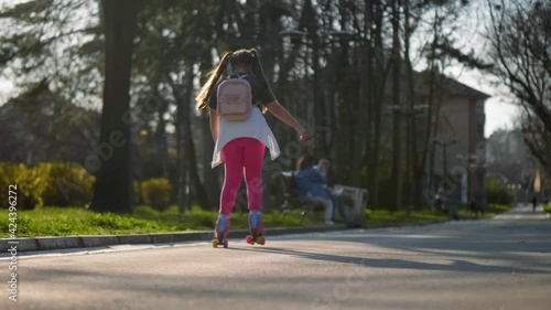 Wallpaper Mural Little girl with a backpack  travels to school on roller skates. Slow motion. Back to school  Torontodigital.ca