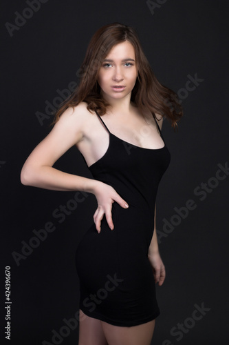 Young brown-haired woman, studio photo on black background