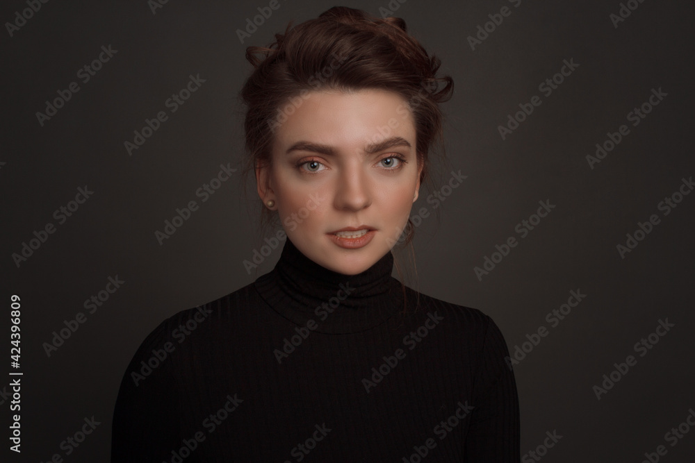 Young brunette woman, with gathered hair hairstyles, in the studio on a black background Young brunette woman, with gathered hair hairstyles, in the studio on a black background