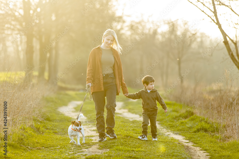 mother and son are walking along the countryside road at sunset mother and son are walking along the countryside road at sunset