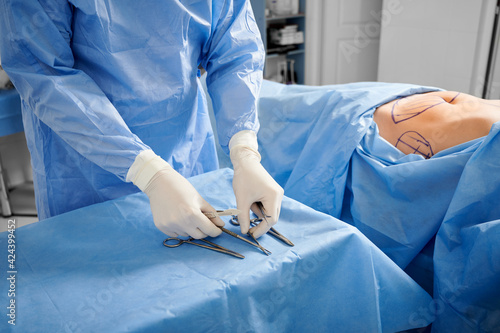 Doctor preparing instruments for plastic surgery in operating room. photo