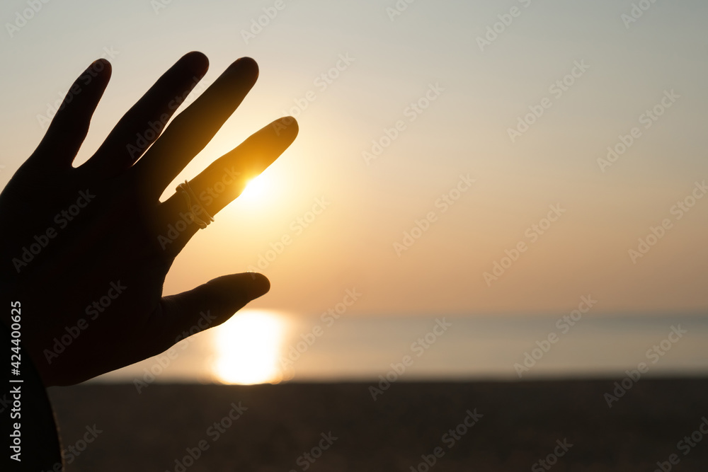 Hand reach out to sunset sky beach sand nature background. Relax and rest in vacation.