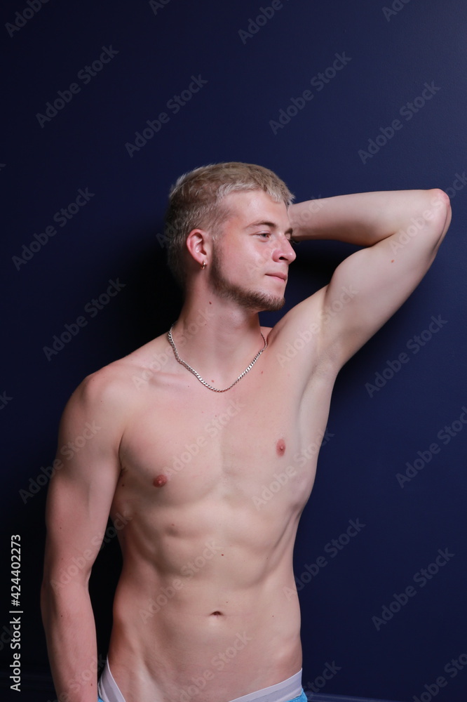 Naklejka premium A young and masculine guy poses in the torso.