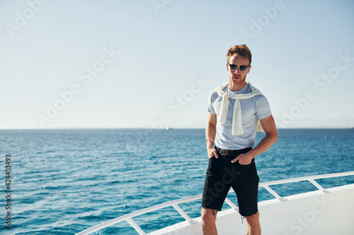 Young male tourist is on the yacht on the sea. Conception of vacation
