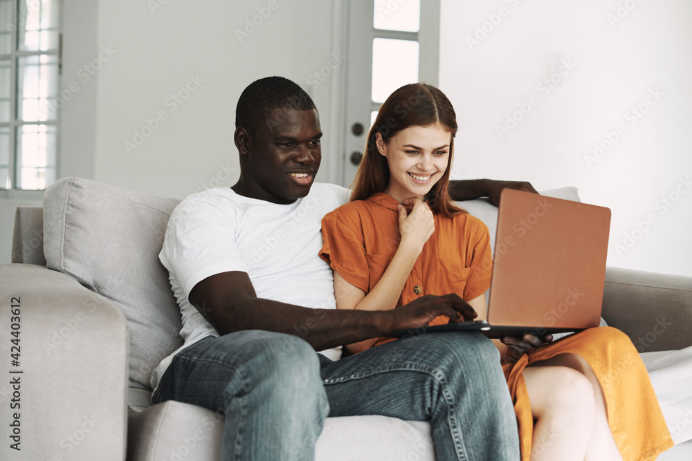 man and woman sitting on the couch in front of laptop communication leisure man and woman sitting on the couch in front of laptop communication leisure