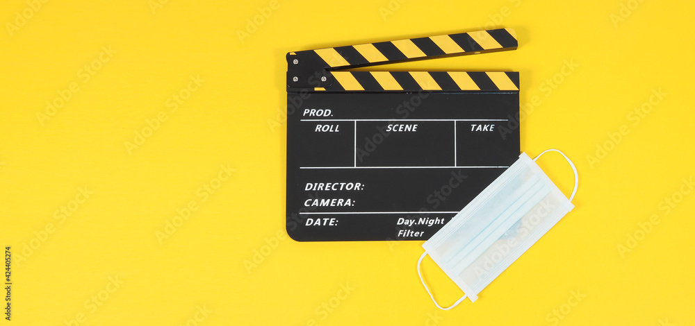 clapper board or movie slate and face mask on yellow background.