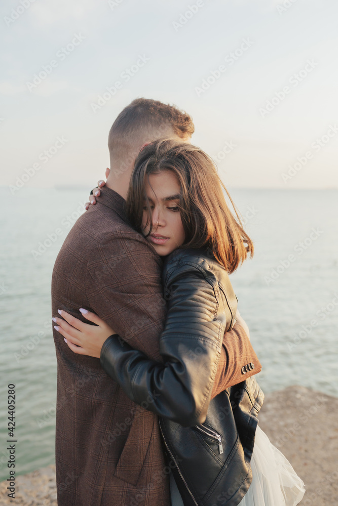 Young passionate couple enjoy a vacation on the beach and hugs. Vertical format. 