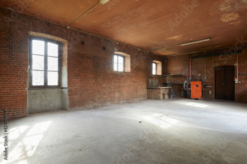 Old workshop interior with brick walls and windows, sunlight