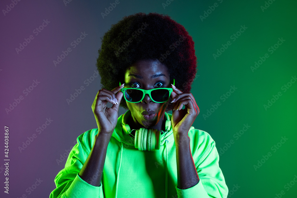 Photo of pretty impressed dark skin lady dressed sweatshirt arms eyewear isolated neon background Photo of pretty impressed dark skin lady dressed sweatshirt arms eyewear isolated neon background
