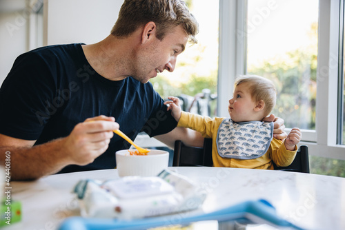 Man on paternity leave feeding his baby