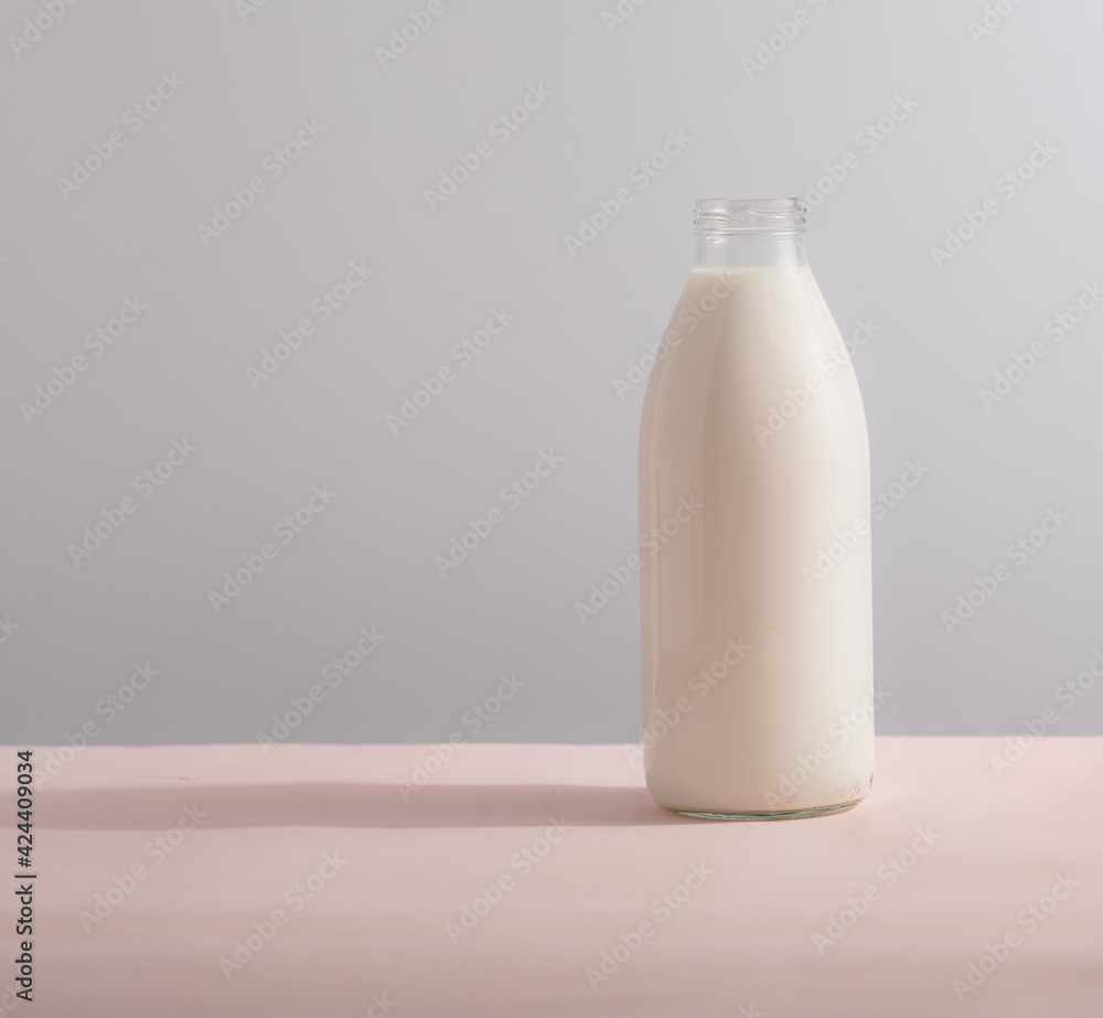 Traditional glass milk bottle on a table on a light background Traditional glass milk bottle on a table on a light background