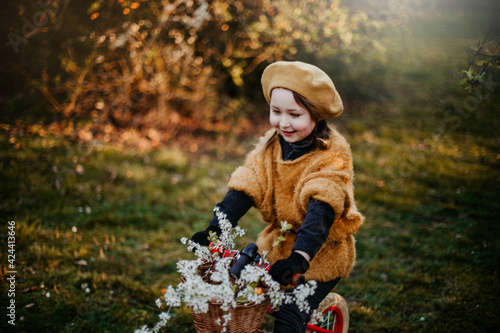 Happy girl riding a bike in the park in early spring
