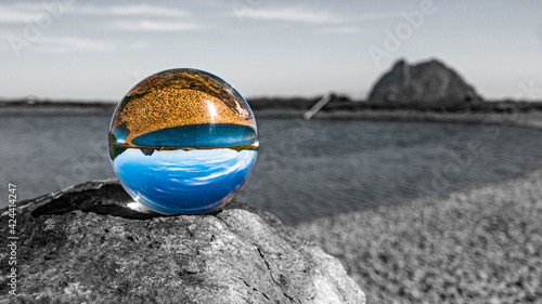 Crystal ball alpine landscape shot with black and white background outside the sphere and details of a rock at Wildkogel Arena, Neukirchen, Salzburg, Austria