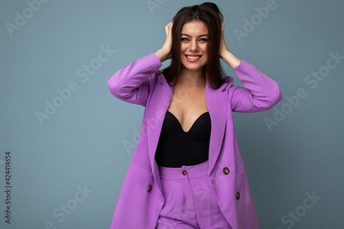 Photo of positive young business long hair brunette woman wearing purple suit isolated on blue background. Copy space