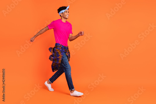 Full length body size photo young guy smiling stepping wearing fashionable clothes isolated bright orange color background