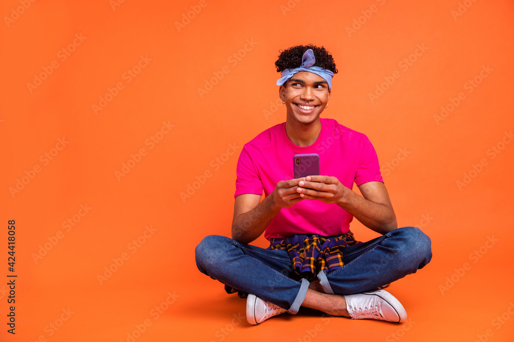 Full length body size photo of curious dreamy hipster reading news with mobile phone isolated vivid orange color background copyspace